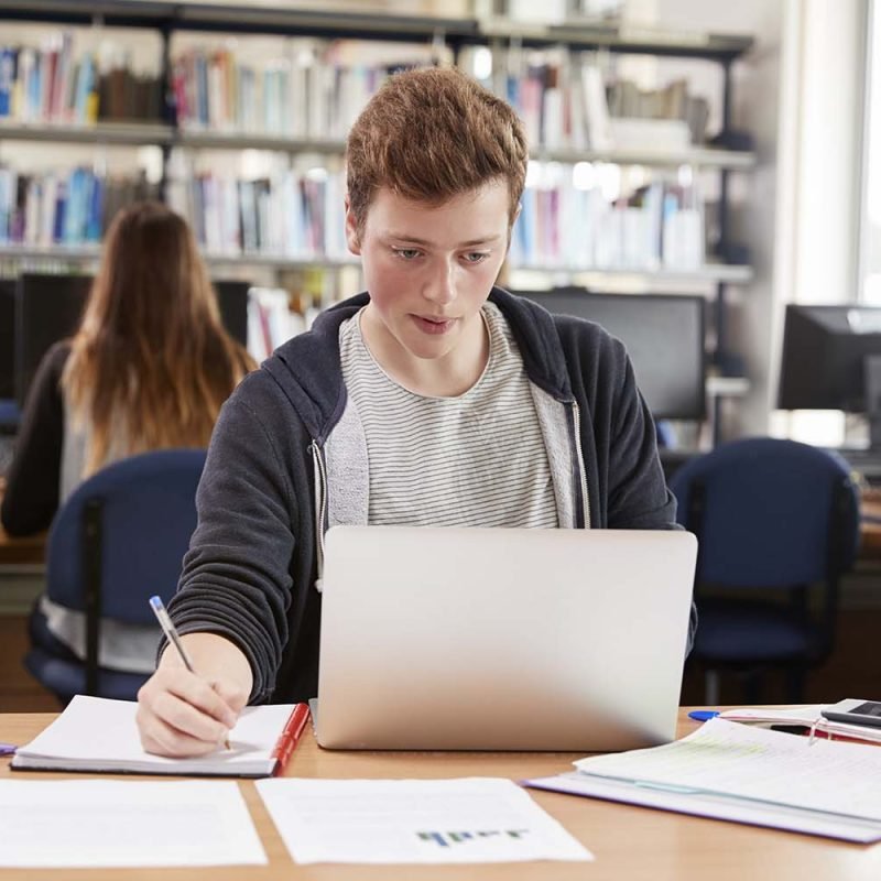 male-student-working-at-laptop-in-college-library-P5ENWP7.jpg